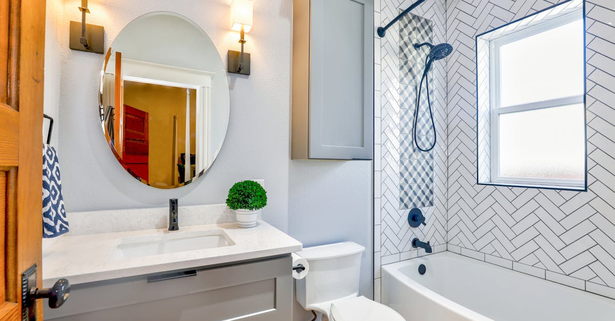elegant modern bathroom featuring chevron tiles oval mirror and sleek fixtures for a contemporary